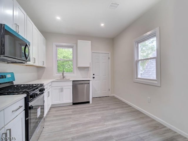 191 Matthew St, City Of Orange Twp, NJ 07050 - kitchen featuring stainless steel appliances, white cabinets, a sink, light countertops, and recessed lighting