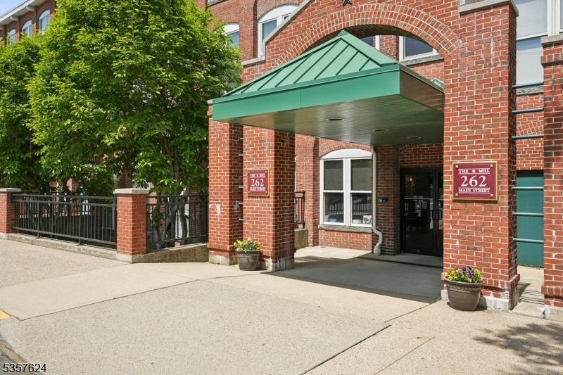 262 Main St, Little Falls Twp, NJ 07424 - property entrance featuring brick siding, fence, and a standing seam roof