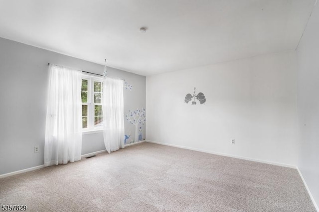 carpeted empty room featuring baseboards