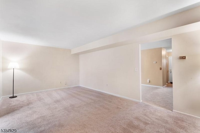 carpeted empty room featuring baseboards
