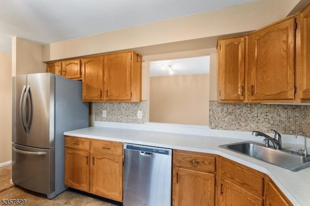 kitchen with stainless steel appliances, a sink, light countertops, and backsplash