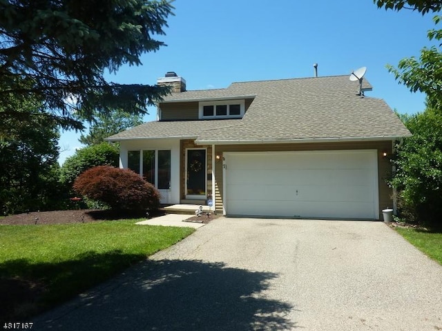 view of front of house featuring a chimney, driveway, a garage, and a shingled roof
