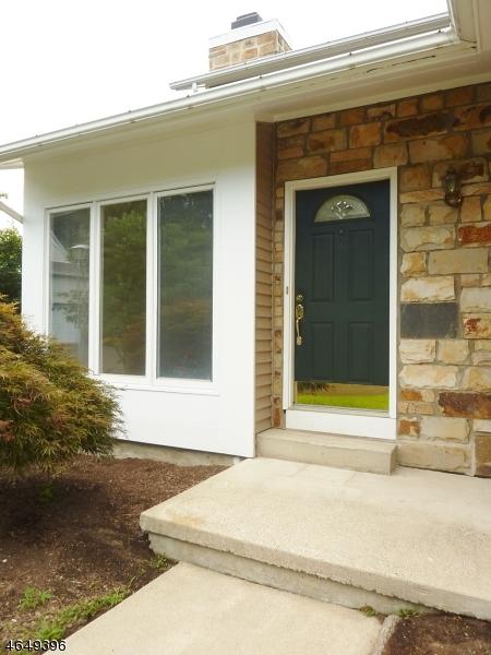 doorway to property featuring stone siding and a chimney