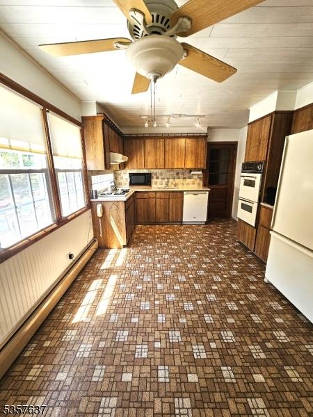 kitchen with white appliances, light countertops, under cabinet range hood, a ceiling fan, and brown cabinets