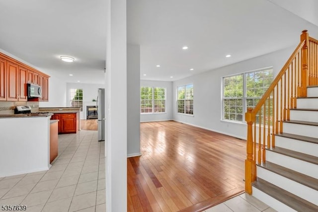 kitchen featuring stainless steel microwave, freestanding refrigerator, healthy amount of natural light, range, and recessed lighting