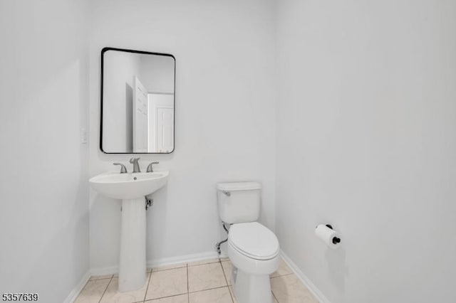 half bath featuring toilet, tile patterned floors, and baseboards