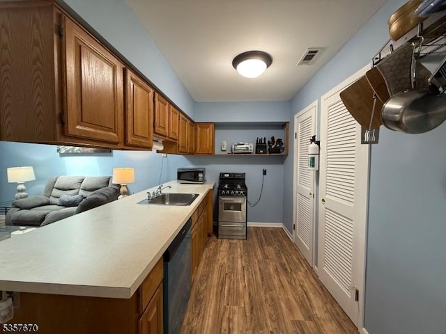 7 Deer Valley Ln Unit 6, Vernon Twp, NJ 07462 - kitchen with stainless steel appliances, a sink, dark wood finished floors, light countertops, and brown cabinetry