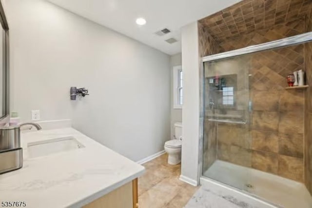 bathroom with toilet, a stall shower, vanity, recessed lighting, and baseboards