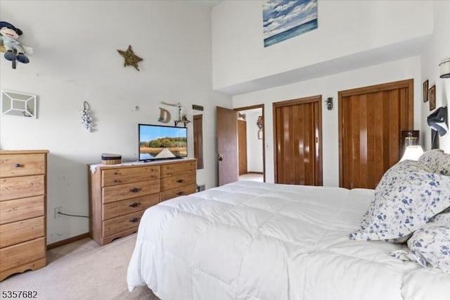 287 Cheyenne Rd, Andover Twp, NJ 07848 - bedroom featuring light carpet, a towering ceiling, two closets, and baseboards