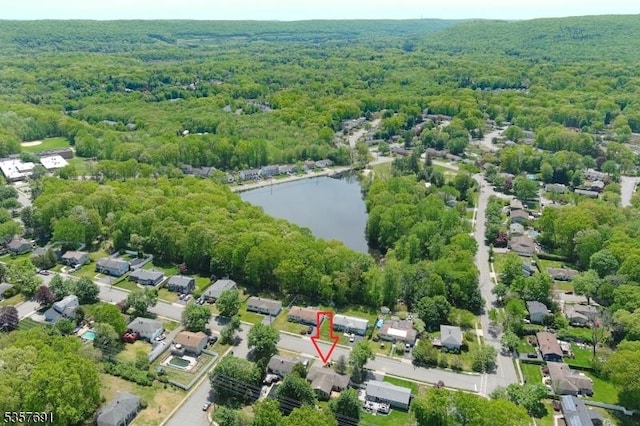 aerial view of property's location featuring a forest and a nearby body of water