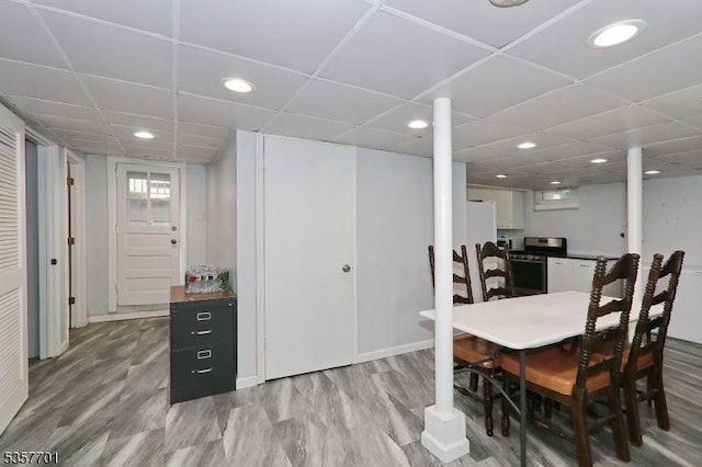 dining area featuring light wood finished floors, recessed lighting, a paneled ceiling, and baseboards