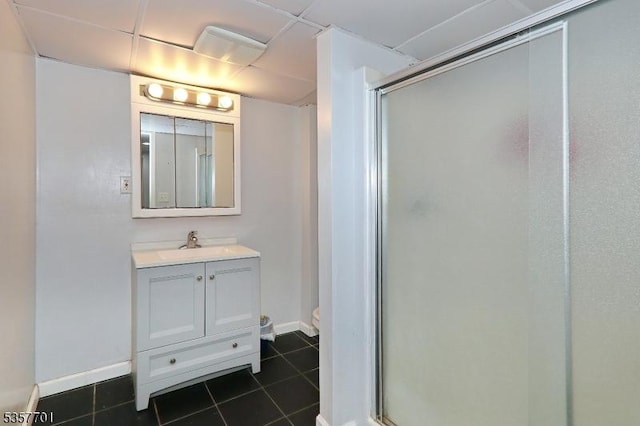full bathroom with a shower stall, tile patterned floors, vanity, baseboards, and toilet