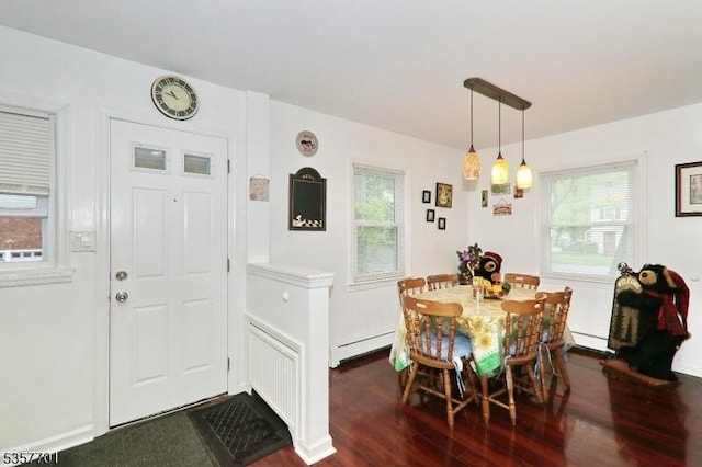 dining space with dark wood finished floors and a baseboard radiator
