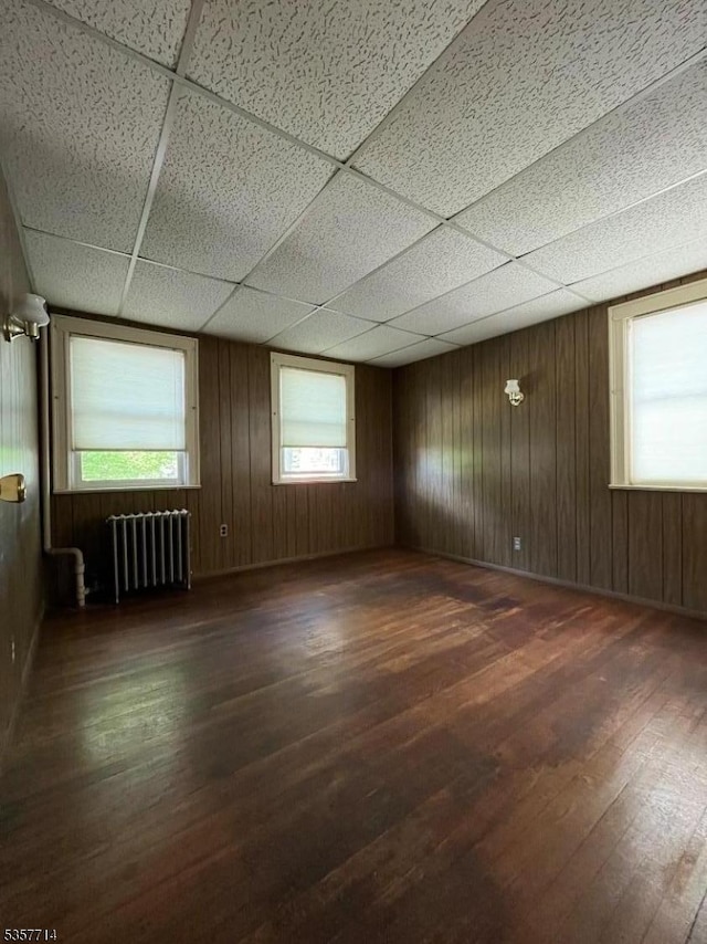 201 W Passaic Ave, Bloomfield Twp, NJ 07003 - spare room featuring radiator heating unit, wood-type flooring, a drop ceiling, and wooden walls