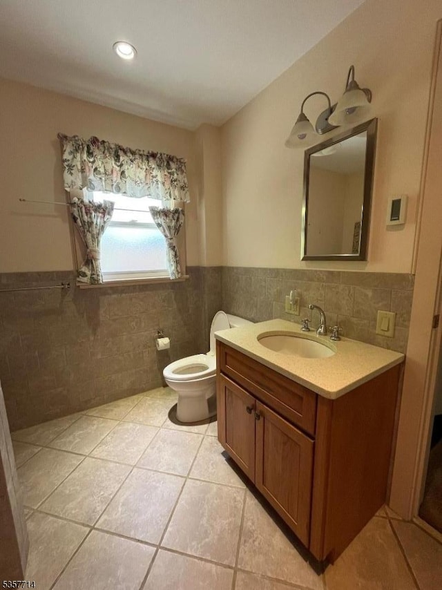 201 W Passaic Ave, Bloomfield Twp, NJ 07003 - bathroom featuring vanity, tile patterned floors, toilet, tile walls, and a wainscoted wall