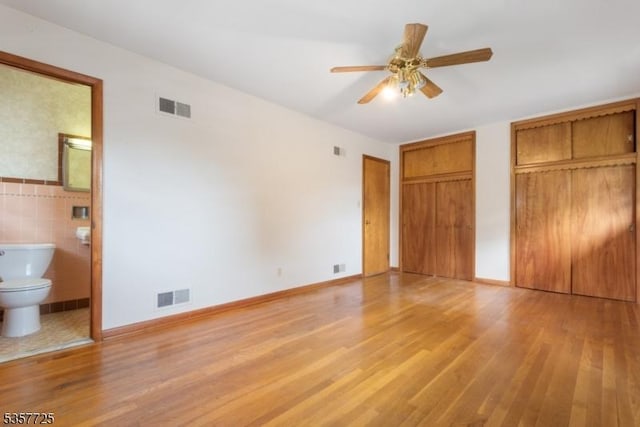 3 Red Maple Ln, Kenilworth Boro, NJ 07033 - unfurnished bedroom with light wood-style flooring, multiple closets, ensuite bath, and tile walls