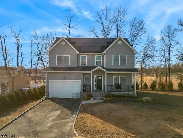 783 Aborn Ave, Woodbridge Twp, NJ 07095 - view of front of property with asphalt driveway, a porch, a garage, and roof mounted solar panels