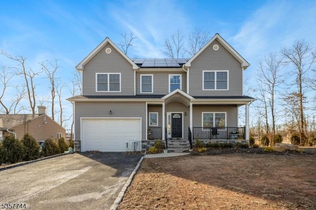 783 Aborn Ave, Woodbridge Twp, NJ 07095 - view of front of house featuring covered porch, driveway, solar panels, and an attached garage