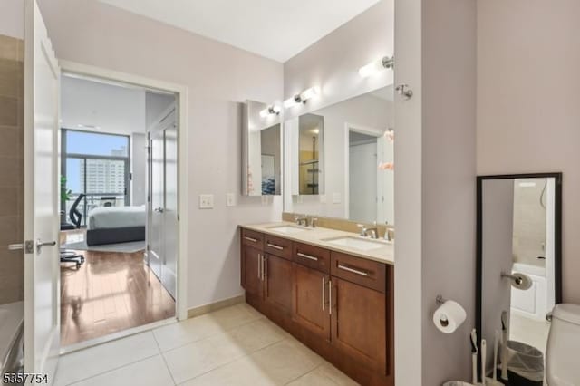 201 Marin Blvd Unit 1507, Jersey City, NJ 07302 - ensuite bathroom featuring double vanity, tile patterned floors, baseboards, and toilet