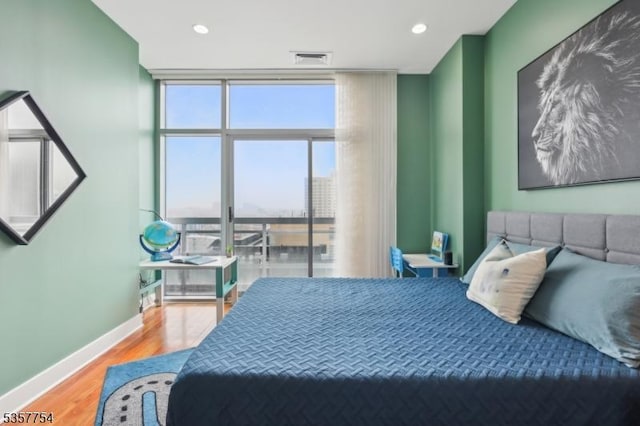 201 Marin Blvd Unit 1507, Jersey City, NJ 07302 - bedroom featuring a wall of windows, wood finished floors, baseboards, and recessed lighting