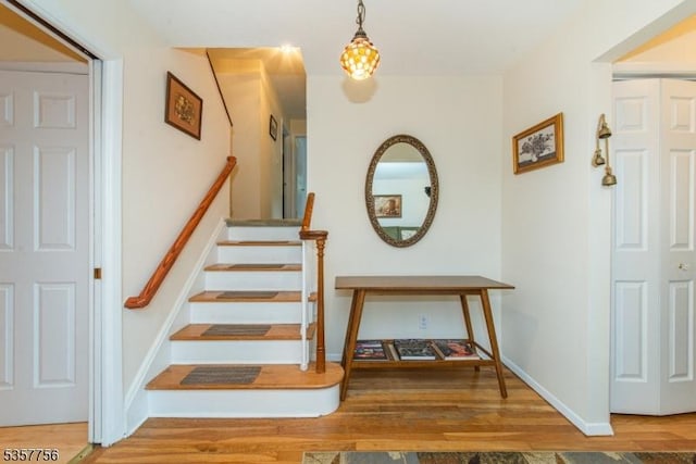 stairs featuring wood finished floors and baseboards