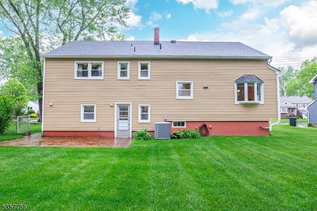 back of house with central AC, a chimney, and a yard