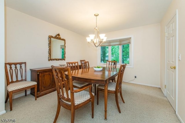 dining room with a chandelier and baseboards