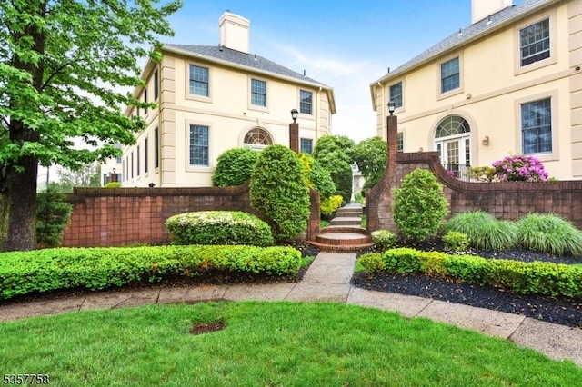 8 Sevell Cir Unit 8, Clark Twp, NJ 07066 - view of front of house with a chimney, stucco siding, and a front yard