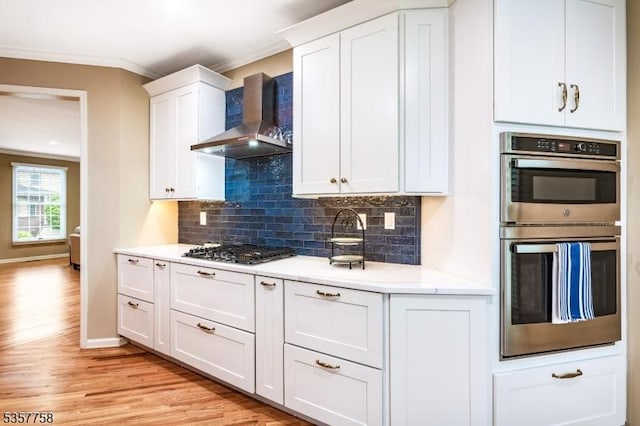 8 Sevell Cir Unit 8, Clark Twp, NJ 07066 - kitchen with wall chimney range hood, crown molding, stainless steel appliances, light wood-style flooring, and decorative backsplash
