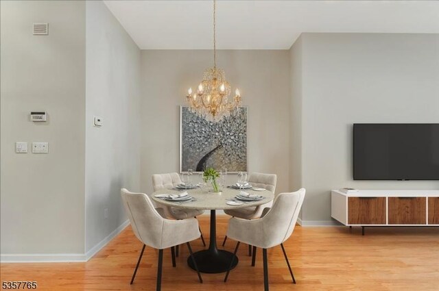 1302 Four Seasons Dr, Wayne Twp, NJ 07470 - dining area featuring a chandelier, baseboards, and light wood finished floors