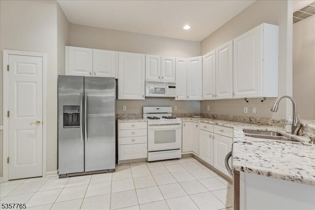 1302 Four Seasons Dr, Wayne Twp, NJ 07470 - kitchen with white appliances, a sink, light stone counters, white cabinets, and light tile patterned floors