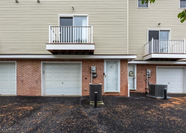 15 Riga Ct, Scotch Plains Twp, NJ 07076 - rear view of property featuring a balcony, a garage, driveway, and brick siding