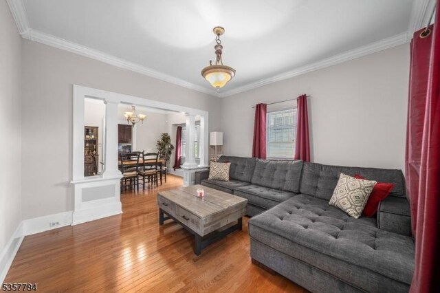 40 Laura Ave, Nutley Twp, NJ 07110 - living room featuring a chandelier, wood finished floors, ornamental molding, decorative columns, and baseboards