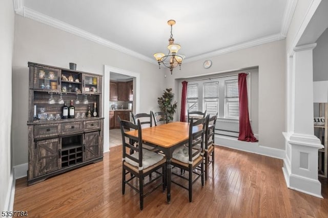 40 Laura Ave, Nutley Twp, NJ 07110 - dining area featuring ornate columns, ornamental molding, a chandelier, wood finished floors, and baseboard heating