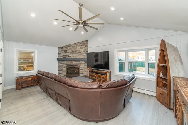 living room featuring a baseboard heating unit, ceiling fan, light wood-style floors, a fireplace, and vaulted ceiling