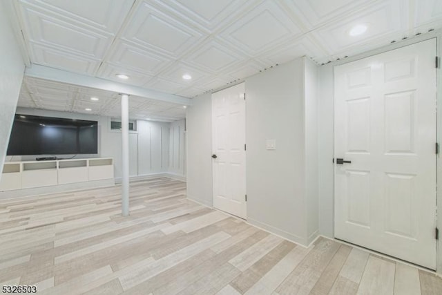 finished basement with recessed lighting, wood finished floors, baseboards, and an ornate ceiling