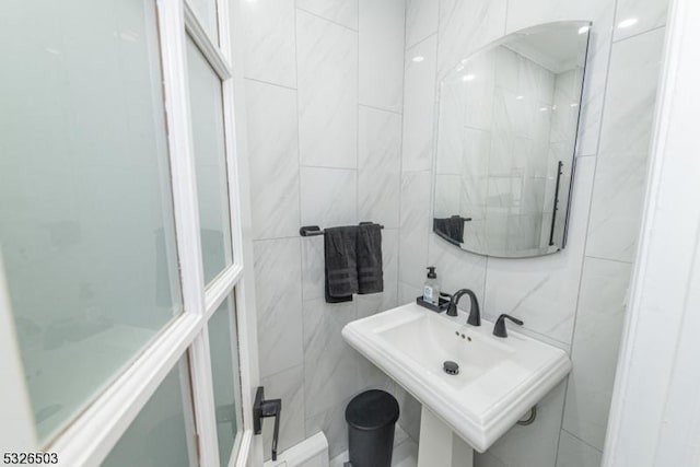 bathroom featuring tile walls and a sink