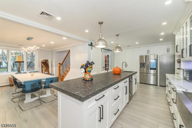 kitchen with stainless steel fridge with ice dispenser, a center island with sink, a sink, glass insert cabinets, and white cabinets