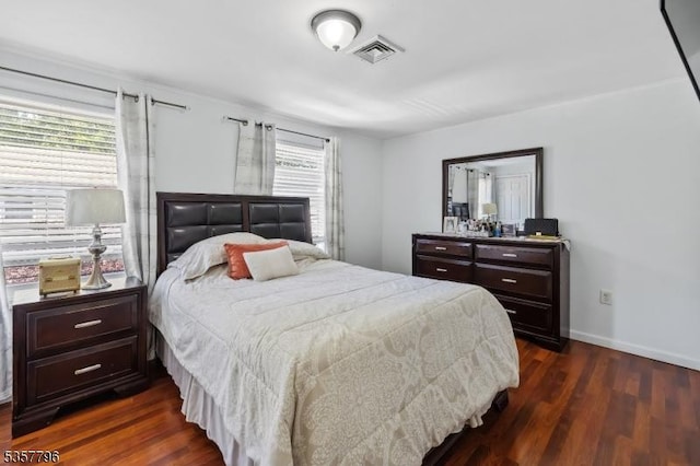 bedroom with dark wood-type flooring and baseboards