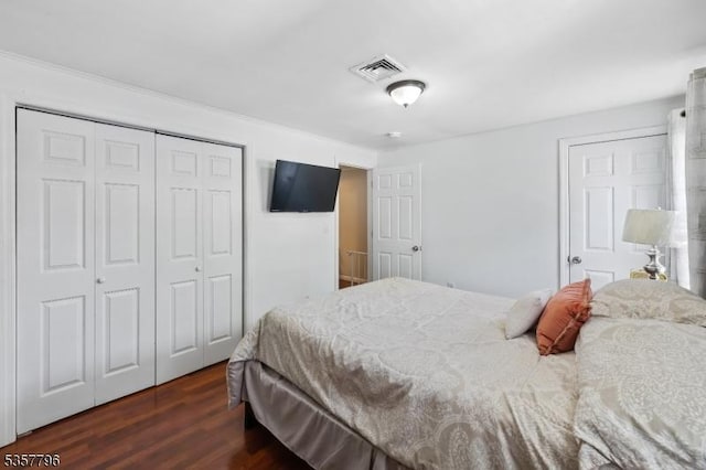 bedroom with dark wood-type flooring and a closet