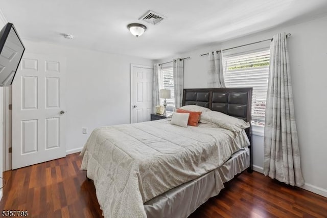 bedroom featuring wood finished floors, a closet, and baseboards