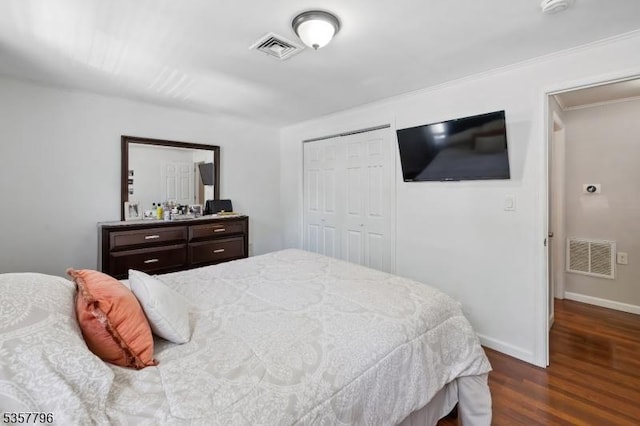 bedroom with dark wood finished floors, a closet, baseboards, and ornamental molding