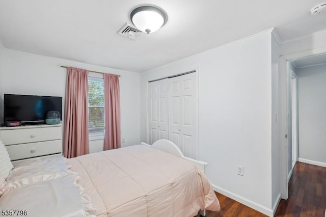 bedroom with wood finished floors, a closet, baseboards, and ornamental molding