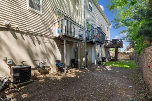 rear view of house featuring central air condition unit, a fenced backyard, and a deck