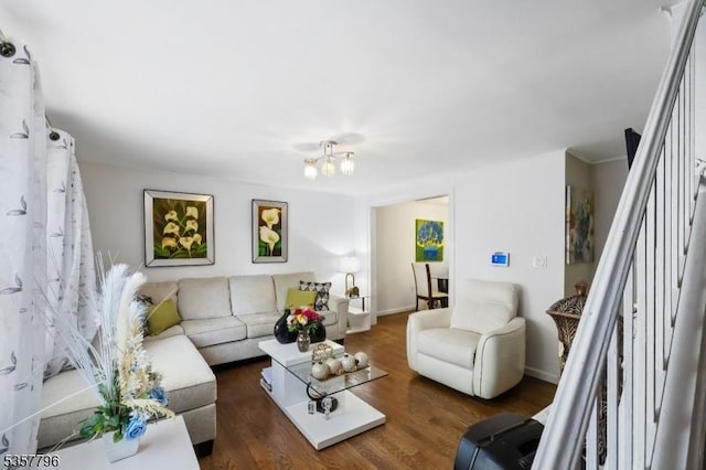 living area with a chandelier, stairs, wood finished floors, and baseboards