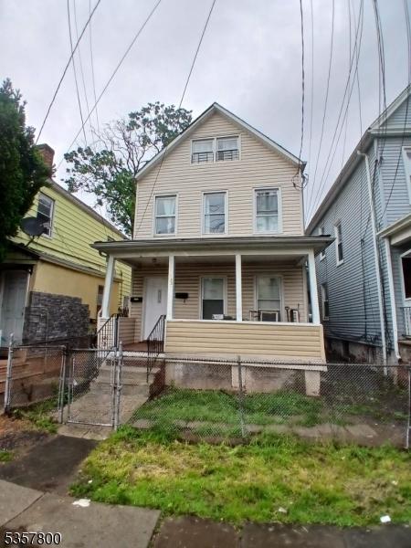 view of front facade featuring covered porch, a fenced front yard, and a gate