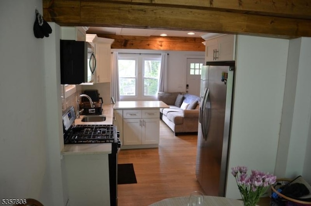 5 Fairview Ave, Mine Hill Twp, NJ 07803 - kitchen featuring stainless steel refrigerator with ice dispenser, gas range oven, a sink, light wood-type flooring, and white cabinetry