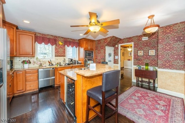 kitchen featuring wallpapered walls, appliances with stainless steel finishes, beverage cooler, a sink, and ceiling fan