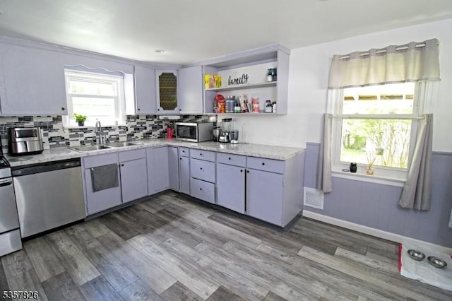 95 Richard St, Rockaway Twp, NJ 07801 - kitchen featuring a sink, stainless steel appliances, wainscoting, wood finished floors, and backsplash