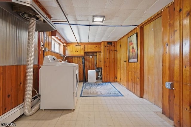 clothes washing area featuring washer / clothes dryer, light flooring, and wood walls